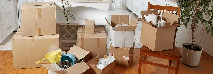 Packed moving boxes and household items in a kitchen before move-out or move-in cleaning, Boston, MA.